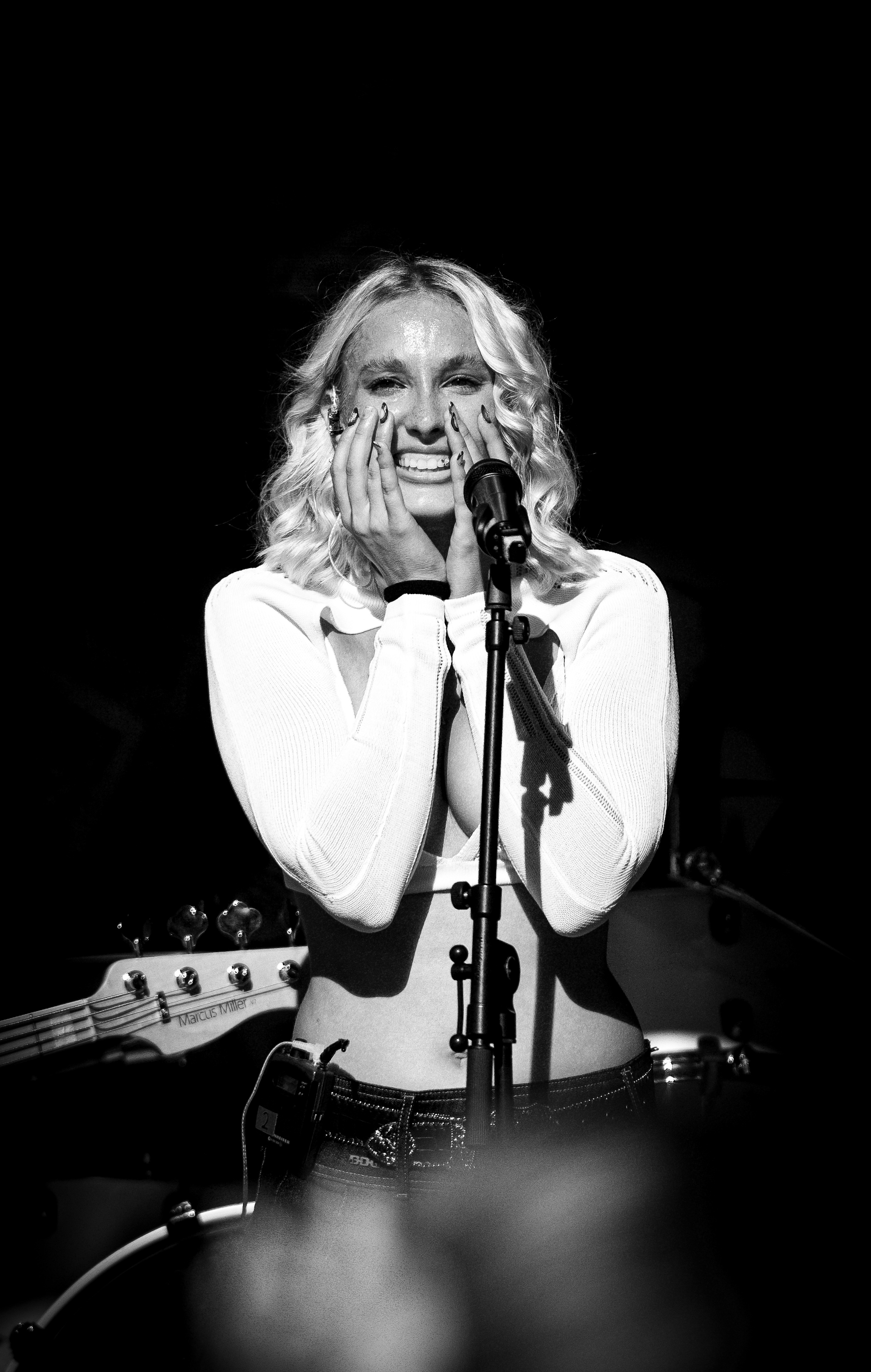 Portrait of Ina, Austrian musician, holding a microphone in warm stage light
